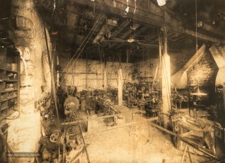 Interior del taller d'A. Bertran Talleres y Maquinaria de Manresa, al número 4 del carrer Dos de Maig de Manresa, amb tota la maquinària i les dues forges a la dreta. (Col·lecció familiar).