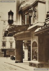 (5/5) Febrer de 1933. Entrada dels Magatzems Jorba de Barcelona. A l’arc de la marquesina que cobreix l’entrada es pot veure un medalló amb el lema de l’empresa “Labor omnia vincit”. El disseny d’aquest emblema, amb els símbols del treball i del comerç, correspon al dibuixant, empleat de l’empresa, Josep Algué, i la frase en llatí està extreta de l’obra Les Geòrgiques, de Virgili.