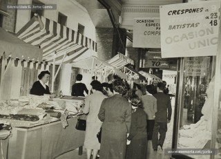 (7/12) Maig de1959. Paradetes amb tot d’ofertes de fira que Magatzems Jorba muntava als porxos que donaven al carrer Nou i al xamfrà de la Plaça de Sant Domènec.