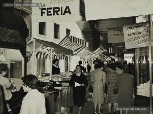 (11/12) Maig de1959. Paradetes amb tot d’ofertes de fira que Magatzems Jorba muntava als porxos que donaven al carrer Nou i al xamfrà de la Plaça de Sant Domènec.