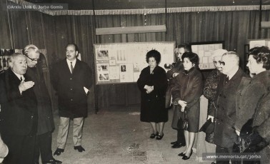 (2/4) 20/2/1969. Presentació de l’exposició d’homenatge a Lluís Uró a càrrec de Pere Jorba Puigsubirà. A la seva esquerra, hi ha el dibuixant Joan Vilanova i, a la seva dreta, el músic Josep Padró i Antoni Fernàndez. L’exposició es feia a la 5ª planta de Cal Jorba.