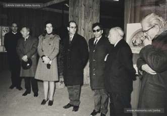 (4/4) 20/2/1969. Presentació de l’exposició d’homenatge a Lluís Uró a càrrec de Pere Jorba Puigsubirà. A la seva esquerra, hi ha el dibuixant Joan Vilanova i, a la seva dreta, el músic Josep Padró i Antoni Fernàndez. L’exposició es feia a la 5ª planta de Cal Jorba.