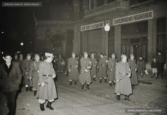 27/12/1958. La banda de cornetes i tambors del batalló de la caserna de Manresa que acompanyava el seguici de l‘emissari reial desfilant pel carrer d’Àngel Guimerà, davant la casa de l’alcalde Josep Moll Vall.