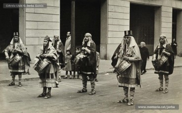 (3/5) 1/1/1963. Pregó de l’arribada dels Reis a Can Jorba que es feia a diferents indrets de la ciutat. Aquí el veiem al carrer d’Àngel Guimerà, a la plaça de Sant Domènec i a la carretera de Vic. El pregoner era Ramon Sibila Basullas.