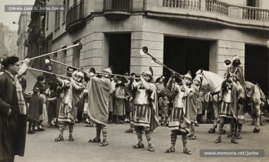 (4/5) 1/1/1963. Pregó de l’arribada dels Reis a Can Jorba que es feia a diferents indrets de la ciutat. Aquí el veiem al carrer d’Àngel Guimerà, a la plaça de Sant Domènec i a la carretera de Vic. El pregoner era Ramon Sibila Basullas.