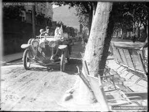 (1/3) Any 1919 o 1920. Cotxes anant pel Passeig de Pere III de Manresa, davant del Casino. El Passeig encara no estava pavimentat però ja hi havia les tradicionals cadires metàl·liques.