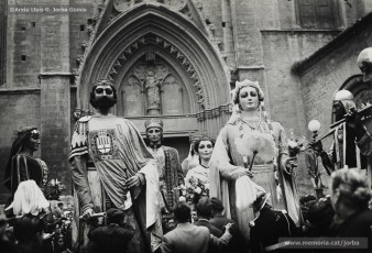 (1/2) 21/10/1951. Sortida de la missa que es va fer a la Seu. Davant de l’església es va fer la benedicció de la nova figura. Els gegants assistents a la trobada, procedents de 9 poblacions diferents, estan plantats al llarg del recorregut; a la segona foto es veuen els gegants de Manresa, al seu darrere els de Barcelona i la Pubilla, i els gegants de Berga als costats.