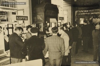 (4/10) Dia del Llibre any 1966. Fira del Llibre organitzada als porxos de Magatzems Jorba com a aportació de l’empresa a la diada de Sant Jordi. S’hi veuen les parades de les llibreries Rubiralta, Torra, Perramon, Escodines, Xipell i Símbol.