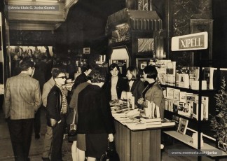 (8/10) Dia del Llibre any 1966. Fira del Llibre organitzada als porxos de Magatzems Jorba com a aportació de l’empresa a la diada de Sant Jordi. S’hi veuen les parades de les llibreries Rubiralta, Torra, Perramon, Escodines, Xipell i Símbol.