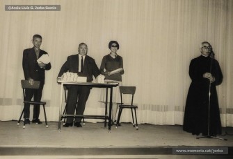 (13/19) Octubre de 1966. Acte de fi de curs 1965-66 de les sessions de cinema infantil. Lliurament del record d’assistència per Pere Jorba Puigsubirà, president del Consell d’Administració de Magatzems Jorba, Dolors Ponsà, empleada de Cal Jorba, i el pare Ferran Torra Sisquella SJ (1893-1990), director de les Congregacions Marianes.