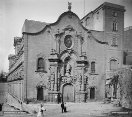 Perspectiva del pòrtic de l'església de la Cova de Sant Ignasi. L'església fou construïda entre els anys 1750 i 1763, però no fou beneïda fins el 1844. L'edifici pertany a l'estil de l'arquitectura anomenada jesuítica. La façana principal que apareix en aquestes imatges és, però, d'inspiració plenament barroca. 
Procedència: Arxiu Jaume Pons i Agulló.