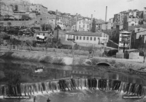 Detall del desguàs del torrent de Sant Ignasi al riu Cardener, en una imatge dels anys vint del segle XX. En primer terme, la resclosa d'origen medieval. Un botó de mostra de Manresa, «ciutat de les cent xemeneies i de les cent inquietuds; de les belleses d'antigor i de frisances per a l'esdevenidor» (L'Abella d'Or, 1928). 
Procedència: Col·lecció família Soler i Mas.