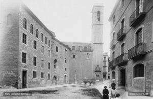 La plaça de Sant Ignasi l'any 1914. Al fons, el campanar de l'església de Sant Ignasi i, just a l'esquerra, el portal de l'hospital de Santa Llúcia, ambdós edificis enderrocats l'any 1936. Aquesta fotografia ens mostra un aspecte molt curós i agençat de la plaça. L'any 1907, l'Ajuntament havia venut l'edifici de l'hospital a la Companyia de Jesús, la qual hi va dur a terme importants obres de restauració.
Procedència: Arxiu Mas