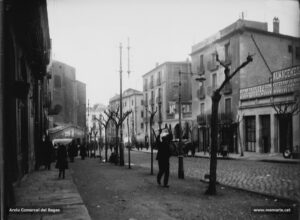 La muralla del Carme en plena activitat comercial durant els anys deu del segle XX. Els magatzems Jorba tenien els tallers i la secció de fotografia instal·lats al començament de la Muralla. També hi havia els tallers de l'ebenista Josep Pich, qui entre el 1913 i el 1921 va esdevenir una filial d'aquests grans magatzems.
Procedència: Arxiu Jaume Pons i Agulló.