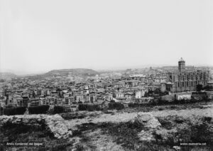 Vista parcial de Manresa, obtinguda des de les restes dels polvorins que envoltaven la torre de Santa Caterina. La panoràmica des d'aquest indret és magnífica: hi despunten la basílica de la Seu i l'església del Carme, amb la caserna als seus peus, sobre el cim del Puigmercadal; al centre de la imatge, la desapareguda església parroquial de Sant Pere Màrtir. Vers l'any 1910, data probable d'aquesta il·lustració, les cases del carrer de Sant Pere encara obstaculitzaven l'ampli accés al centre de la ciutat pel portal de les Piques, sector conegut com la Reforma. Més enllà, els xipresos del claustre del convent de les Germanes Caputxines al carrer de Talamanca. 
Procedència: Col·lecció Jaume Blanch i Carreras. (Fotografia de Francesc Blanch i Pons)