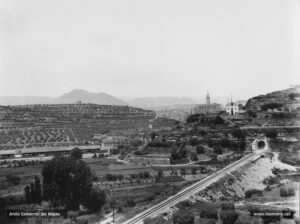 Perspectiva sud-oriental de la ciutat a finals dels anys vint del segle XX. En primer terme, la via dels Ferrocarrils Catalans Manresa-Barcelona, inaugurada l'any 1926; a l'extrem esquerre, la torre de Santa Caterina, a sota els nous molls de l'estació del Nord, i al fons, airosa, sobresurt la Seu. 
Procedència: Arxiu Jaume Pons i Agulló