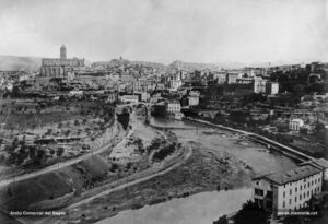 Panoràmica de Manresa, realitzada des de Sant Pau, molt probablement al principi dels anys noranta del segle XIX. En primer terme i a la dreta, la fàbrica de les Roques de Sant Pau; a l'esquerra, la via del ferrocarril del Nord. Al mig, el Pont Vell i la fàbrica Argemí, Vila i Cia, o del Pont Vell, enderrocada a l'agost del 1985. Més enllà i a l'extrem esquerre, la basílica de la Seu, amb el corresponent casquet que coronava originàriament el campanar, i l'església del Carme a la seva dreta. L'edifici de la Cova de Sant Ignasi encara no havia ampliat les seves dependències amb la construcció de la Casa d'Exercicis. 

Procedència: Arxiu Comarcal del Bages.