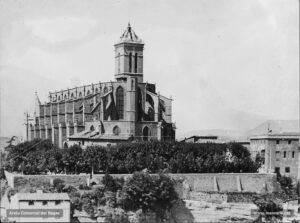 La Seu i els jardins que l'envolten. A la dreta, l'edifici dels jutjats, que també des del 1882 encabí provisionalment la sala de l'Audiència del Criminal. La fotografia degué ser presa l'any 1917: el nou baptisteri ja hi és adossat, mentre que l'agulla piramidal del campanar és a punt de ser aixecada. Els jardins del parc foren condicionats l'any 1887. 
Procedència: Arxiu Jaume Pons i Agulló