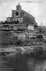 Vista parcial de la Seu i la palanca de ferro cap a inicis del segle XX. Els famosos magatzems El Sigle aprofitaven la paret del mur de contenció que envoltava el conjunt de la Seu per anunciar-se als viatgers que arribaven a l'estació.
Procedència: Arxiu Comarcal del Bages