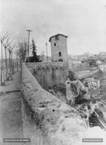 La Casa de les Ànimes, en un extrem del parc de la Seu, al tombant de segle XX. Al fons i a la dreta, la Cova, la casa de la Culla i el convent de Santa Clara. La Casa de les Ànimes, bastida l'any 1760, era una dependència de l'antic fossar de la Seu. A les 7 de la tarda del 3 de setembre de 1906 va ser objecte d'un simulacre d'extinció de foc desenvolupat pels bombers. El Diario de Avisos ressenyava aquest esdeveniment així: «El fuego que se inició en la parte alta de la casa, fue propagándose a todas las dependencias de la misma, produciendo un efecto imponente las llamas que se escapaban por el tejado, ventanas y puertas de entrada, en tanto los bomberos simulaban las operaciones de salvamento y extinción, sumisos a la voz de las cornetas y pitos, con una precisión digna de toda suerte de elogios. Hiciéronse grandes refuerzos para derrumbar de una vez toda la casa, pero no pudo lograrse más que parcialmente, gracias a la consistencia de sus columnas interiores» . 
Procedència: Col·lecció Andreu Argelich