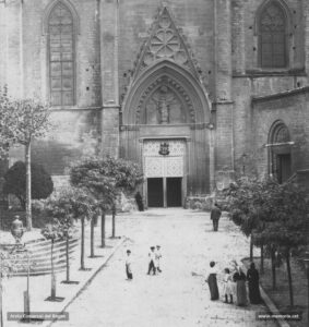 Vista del portal de l'entrada lateral de la basílica de la Seu situat al mur nord, prop de la capçalera.
Procedència: Arxiu Comarcal del Bages