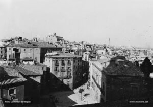 Vista de la ciutat vella des de les voltes de la Seu l'any 1921. Al cantó dret de la baixada de la Seu s'observa l'antic Palau de Justícia; al mig, destaca la casa Planell, d'estil neoclàssic, entre el carrer del Bisbe i la cantonada amb la baixada del Pòpul; i, just al darrere, l'imposant edifici de les cases consistorials o Casa de la Ciutat. Al fons, el Carme.
Procedència: Arxiu Mas.