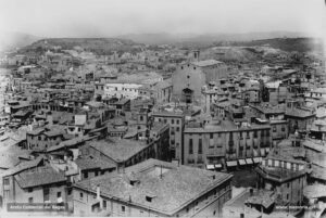 Magnífica vista del nucli antic de la ciutat, feta des del campanar de la Seu, entrats els anys vint del segle XX. A l'horitzó es percep la muntanya de Puigterrà, totalment pelada, la qual es tenia la intenció de transformar en parc públic en aquells moments. L'església del Carme, que fou enderrocada l'any 1936, i la caserna presideixen el nucli antic, juntament amb la Casa de la Ciutat i la Plaça Major. Més enllà, es pot observar com s'ha anat eixamplant el casc urbà, tot guanyant terreny de manera gradual al regadiu.
Procedència: Arxiu Jaume Pons i Agulló.