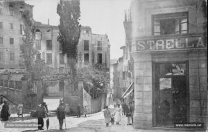 Antiga plaça del Pes vell de la farina al carrer de les Piques, entre els anys deu i el 1923. Al mig, l'Ateneu de la classe obrera. Aquesta plaça va ser refeta el darre terç del segle XIX.
Procedència: Arxiu Jaume Pons i Agulló