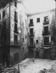 Les antigues cases (ca la Mònica i cal Torné) que hi havia abans de la construcció de l'actual casa Llissach. Aquestes cases es van haver d'enderrocar per dur a terme l'obertura del carrer d'Alfons XII (actual Passeig de la República), tot tallant de ple el carrer de Talamanca, que havia de comunicar directament el pont de l'estació que s'havia projectat amb la Plana de l'Om.
Procedència: Col·lecció Jaume Blanch i Carreras (Fotografia de Francesc Blanch i Pons)