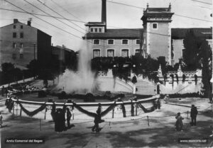 L'actual plaça de Crist Rei, habilitada amb una font lluminosa per festejar la inauguració dels serveis de la cooperativa Manresana d'Electricitat, en la Festa Major de 1912. A l'inici de la perllongació Guimerà, s'observa la fàbrica Lluvià. Aquest conjunt fabril va ser bastit a iniciativa dels fabricants vetaires Lluvià i Vidal al costat del torrent dels Predicadors al final dels anys vuitanta del segle XIX. Després de ser ocupat per diferents empreses i activitats industrials, l'edifici deixà de funcionar l'any 1975. Posteriorment, en el solar que ocupava la fàbrica s'aixecà l'edifici Manresa Centre.
Procedència: Arxiu Comarcal del Bages