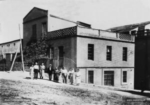 Detall de la casa, propietat de la família Galí, emplaçada a la cantonada del carrer del Bruc amb el carrer de l'era de l'Esquerra. Diversos membres de la família posen davant de casa seva el 15 de setembre de 1923.
Procedència: Col·lecció Salvador Palau