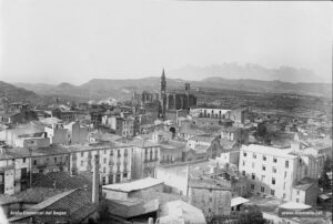 Vista de la carretera de Vic, obtinguda des del turó de Puigterrà, en plena dècada dels anys vint del segle passat. Al centre de la fotografia sobresurt la Seu, l'església del Carme i la caserna, i també el mercat dels Infants, projectat per l'arquitecte Ignasi Oms i Ponsa l'any 1900, i que es coneixia amb el nom de «Les Mocaderes» . En primer terme i a l'angle esquerre de la perspectiva, la xemeneia de la fàbrica de licor Casas, coneguda popularment com la «Brisa».
Procedència: Arxiu Jaume Pons i Agulló.