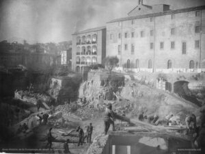 Fotografia de les obres de construcció de la nova casa de tercera provació (l'actual Casa d'Exercicis). Les obres s'iniciaren el 27 de juliol de 1894 i van ser finançades per Dolors Serra i de Chopitea, vídua de Pons. El nou edifici estableix una connexió interior perfecta amb la Cova -a través de la sagristia- i amb la Casa antiga. En les obres de l'actual Casa d'Exercicis treballaren ininterrompudament uns 140 obrers, de tal manera que la construcció fou molt ràpida. La benedicció del nou edifici es va dur a terme el 21 de setembre de 1896, en una senzilla cerimònia de caràcter religiós, sense que les autoritats municipals hi fossin presents.
Procedència: Arxiu Històric de la Companyia de Jesús de Catalunya.