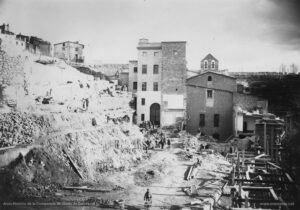 Fotografia de les obres de construcció de la nova casa de tercera provació (l'actual Casa d'Exercicis). Les obres s'iniciaren el 27 de juliol de 1894 i van ser finançades per Dolors Serra i de Chopitea, vídua de Pons. El nou edifici estableix una connexió interior perfecta amb la Cova -a través de la sagristia- i amb la Casa antiga. En les obres de l'actual Casa d'Exercicis treballaren ininterrompudament uns 140 obrers, de tal manera que la construcció fou molt ràpida. La benedicció del nou edifici es va dur a terme el 21 de setembre de 1896, en una senzilla cerimònia de caràcter religiós, sense que les autoritats municipals hi fossin presents.
Procedència: Arxiu Històric de la Companyia de Jesús de Catalunya.