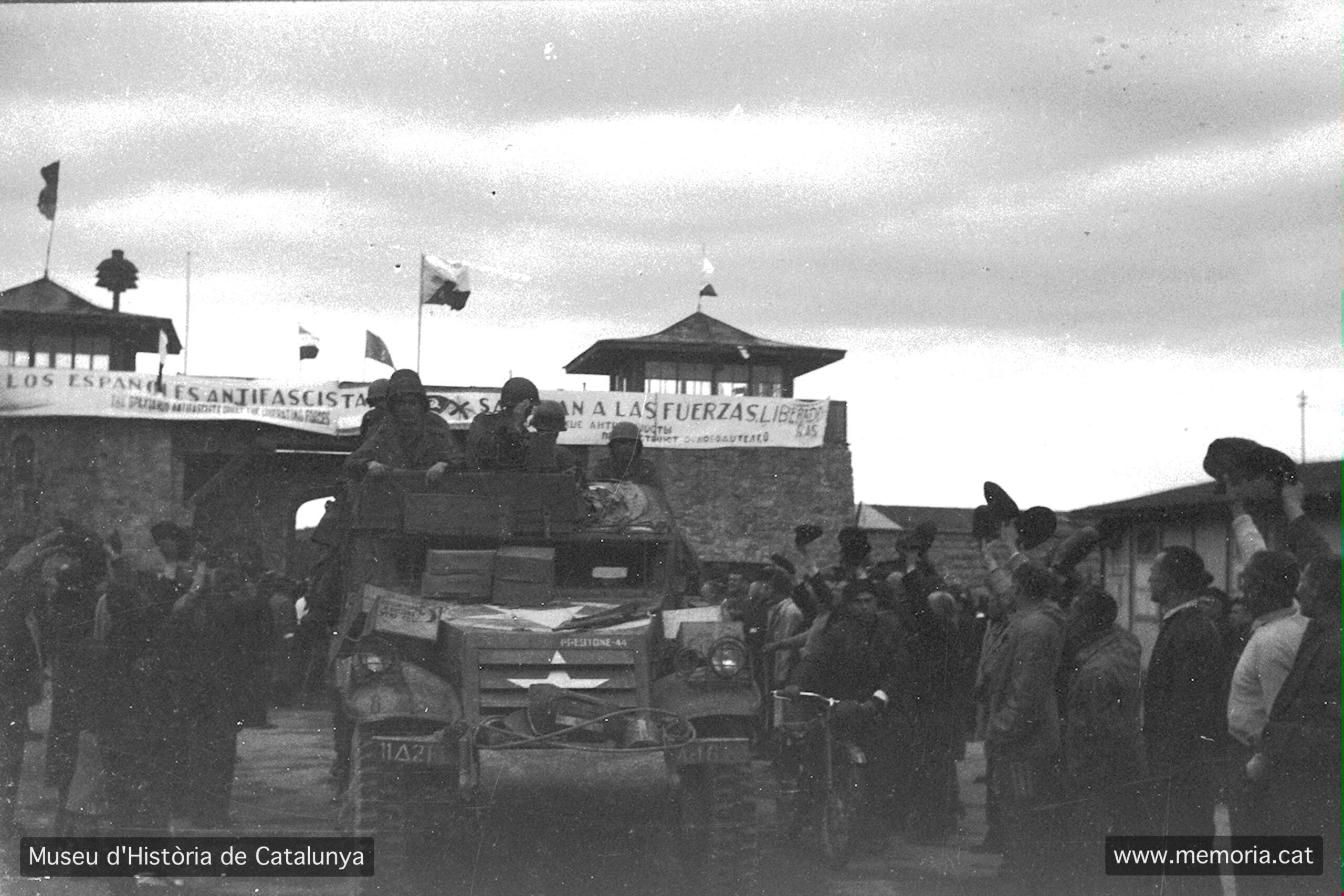 Entrada dels tancs nord-americans al camp de Mauthausen. En aquesta fotografia es pot llegir la banderola pintada per Francesc Teix donant la benvinguda a les forces alliberadores: “Los españoles antifascistas saludan a las fuerzas liberadoras”. El text estava escrit en castellà, anglès i rus. Fotografia de Francesc Boix, 5-7 de maig de 1945. MHC. Fons Amical de Mauthausen-Francesc Boix Campo.