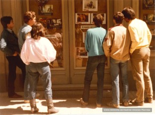 Joves davant dels típics quadres fotogrames anunciant la pel.lícula de la setmana.

