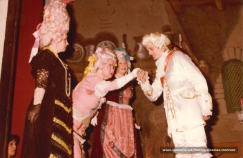 Josep Isart besa la mà a Montserrat Garriga, sota la mirada de la Carme Cot, La Glòria Roses en vestit negre. Treu el cap a l'esquerra Lola Monrós. "La Ventafocs" (1983)